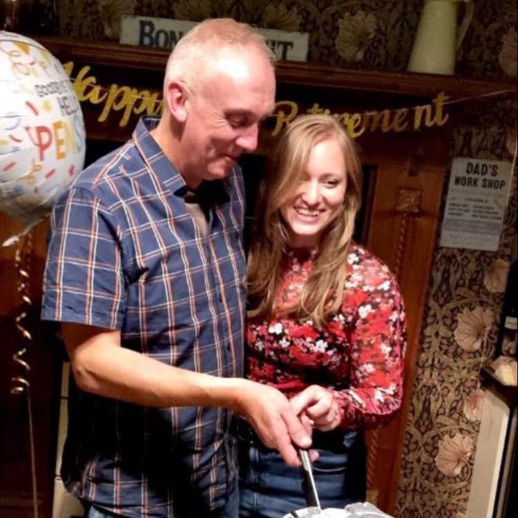 A smiling couple cutting a cake at their engagement party.