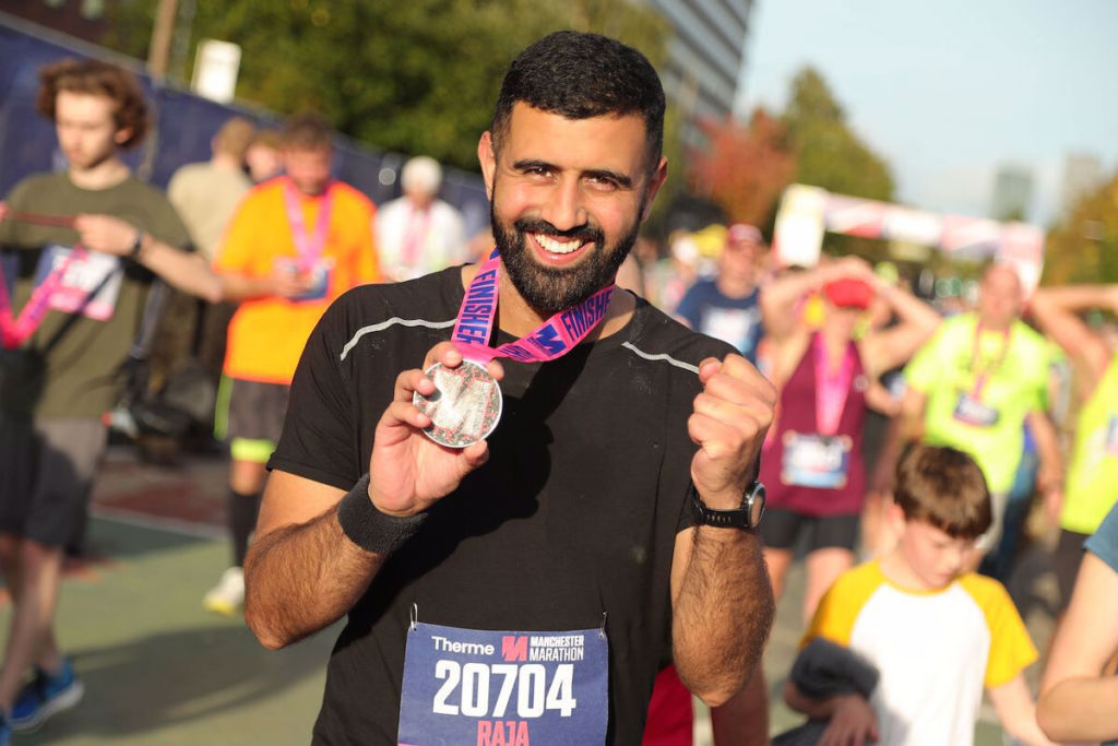 Man at finish line with medal